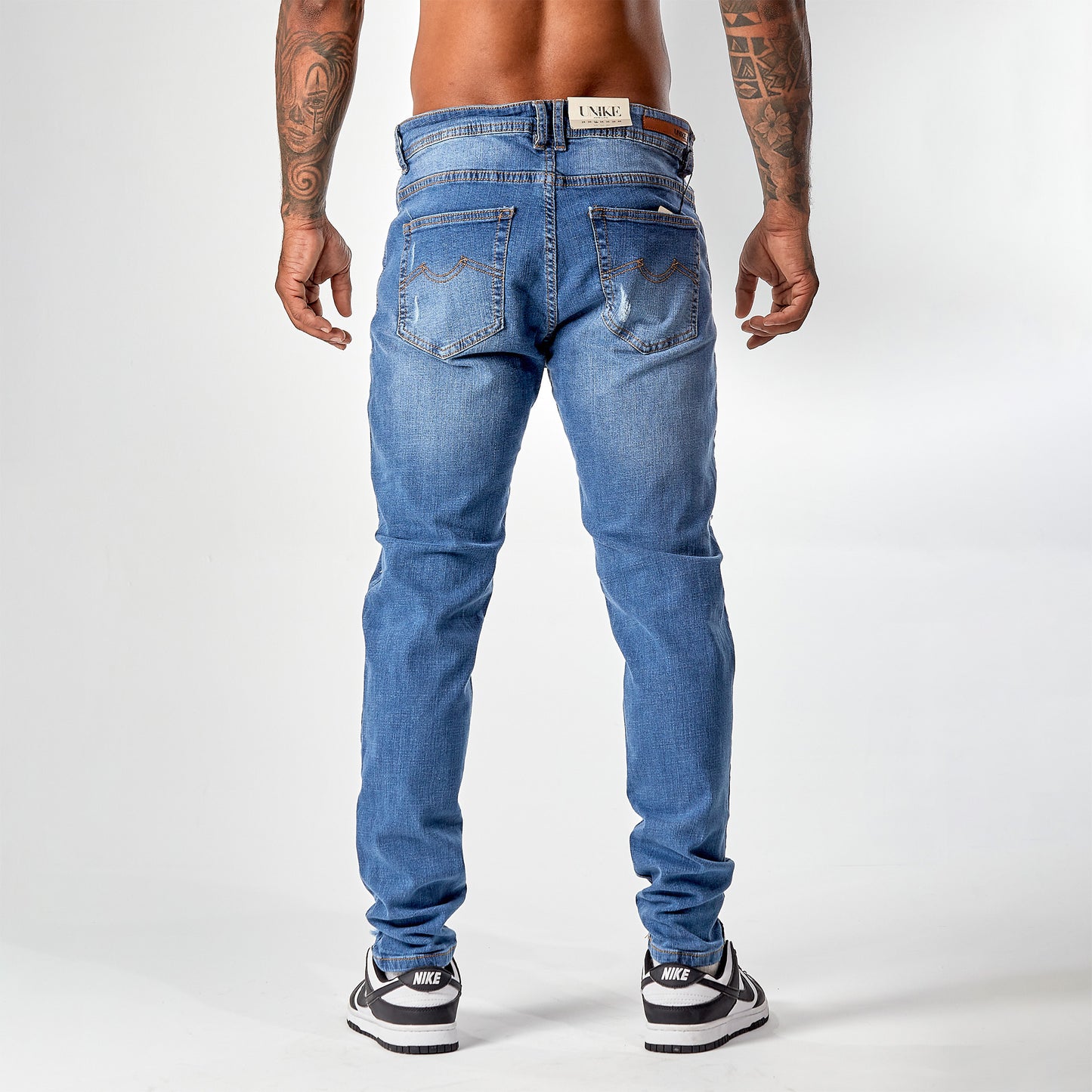 Jean caballero azul medio roto en rodilla borde café