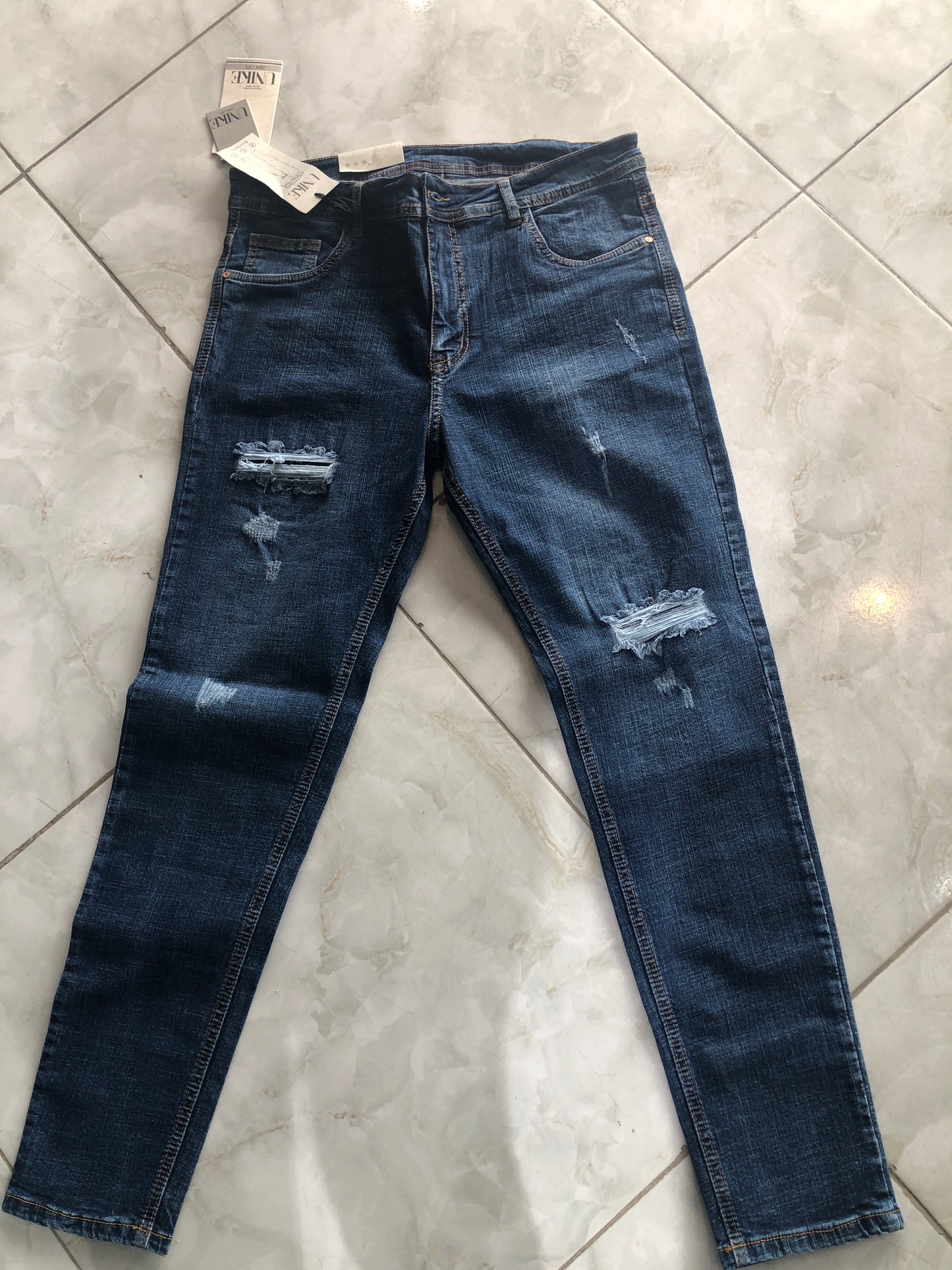 Jean caballero azul oscuro roto en rodillas bordado café